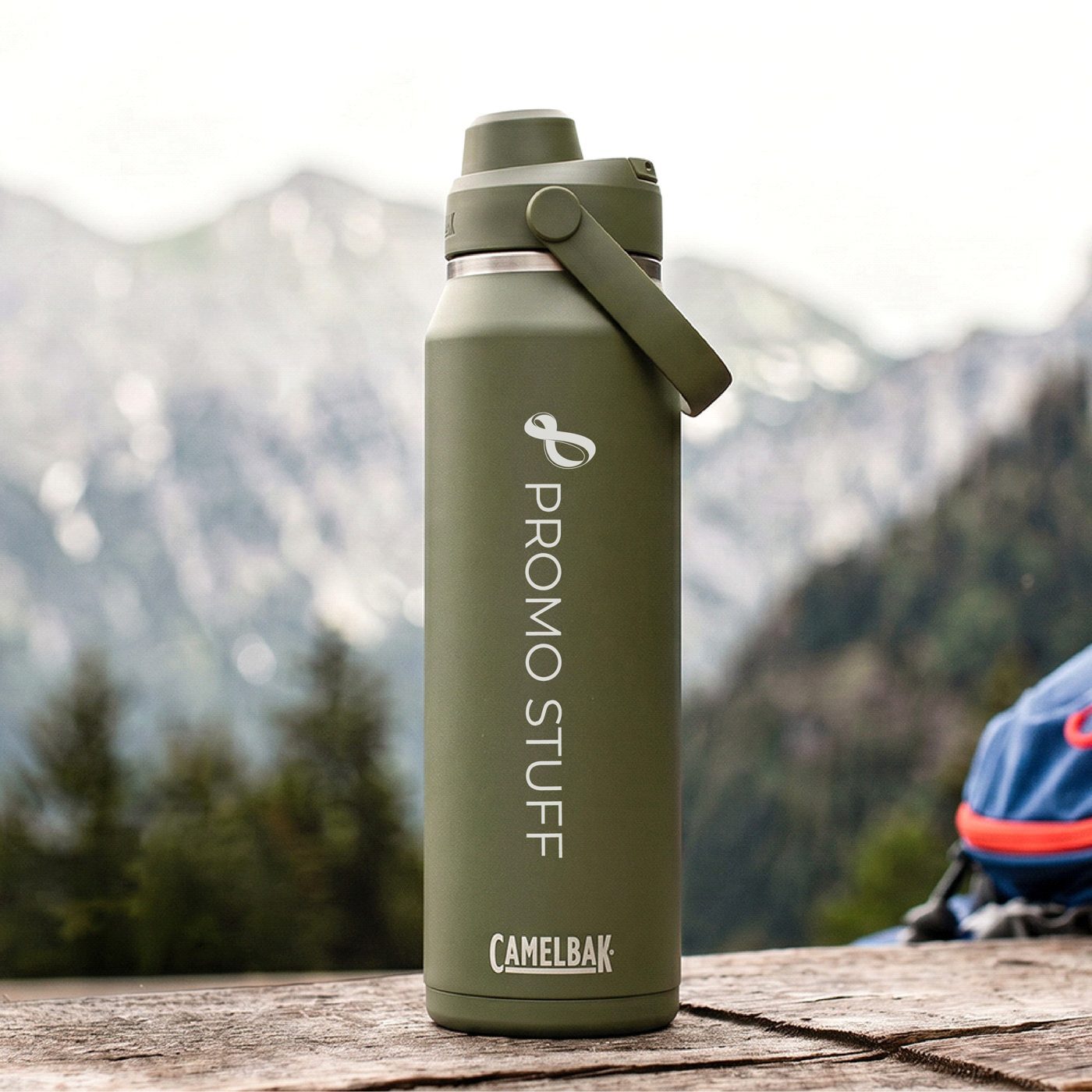 CamelBak drink bottle printed with the Promo Stuff logo, on a rock with mountains behind